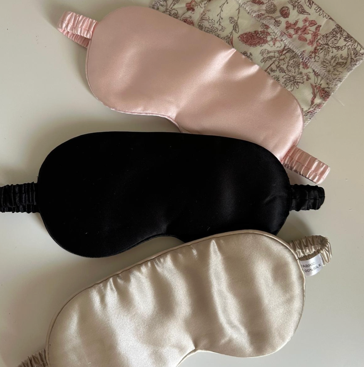 Trois masques de nuit en soie : rose poudré, noir et beige champagne